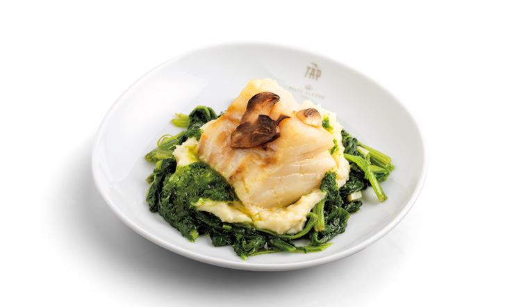 Photograph of a white plate with the TAP logo, with Cod, Potato Cream and Spinach.