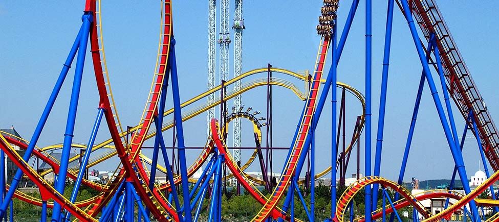Photo of a roller coaster in shades of dark blue, yellow, and red.